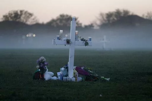 In this Feb. 17, 2018, file photo, an early morning fog rises where 17 memorial crosses were placed for the 17 students and faculty killed in the shooting at Marjory Stoneman Douglas High School in Parkland, Fla. The 12 jurors and 10 alternates chosen this past week to decide whether Cruz is executed will be exposed to horrific images and emotional testimony, but must deal with any mental anguish alone. (AP Photo/Gerald Herbert, File)