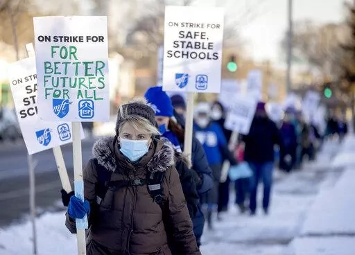 Minneapolis teachers and supporters picket at 34th street and Chicago Avenue South in Minneapolis, on Tuesday, March 8, 2022.  Teachers in Minneapolis have reached a tentative agreement to end a more than two-week strike over pay and other issues that idled some 29,000 students and around 4,500 educators and staff. The district and the union for teachers and staff announced the deal early Friday, March 25. (Elizabeth Flores /Star Tribune via AP)