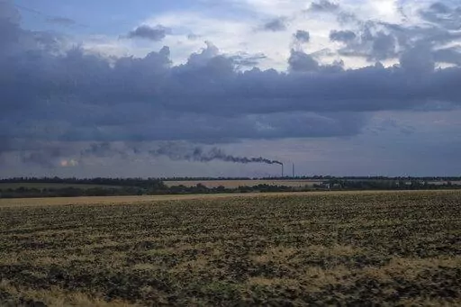 Grain fields backdropped by a power plant in Donetsk region, eastern Ukraine, Friday, July 22, 2022. (AP Photo/Nariman El-Mofty)