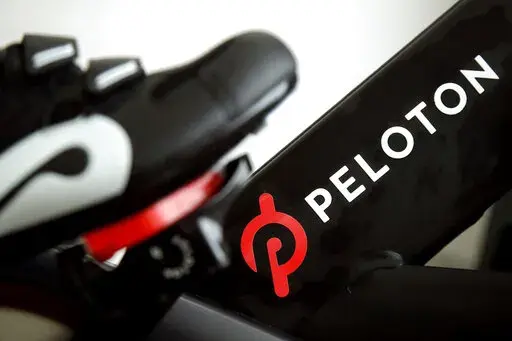 This Nov. 19, 2019 file photo shows the logo on a Peloton bike in San Francisco. Peloton's loss widened in its fiscal third quarter and sales continued to slow as the company contends with a further cooling of the exercise-at-home trend .  Shares tumbled more than 25% before the market open on Tuesday, May 10, 2022. (AP Photo/Jeff Chiu, File)