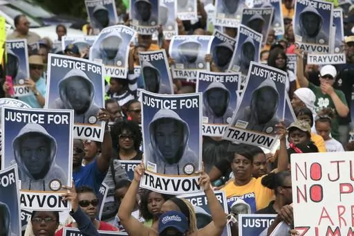 Protesters hold signs during a march and rally for slain teenager Trayvon Martin, March 31, 2012, in Sanford, Fla. The Black Lives Matter movement hits a milestone on Thursday, July 13, 2023, marking 10 years since its 2013 founding in response to the acquittal of the man who fatally shot Martin. Gunned down in a Florida gated community where his father lived in 2012, Martin was one of the earliest symbols of a movement that now wields influence in politics, law enforcement and broader conversat