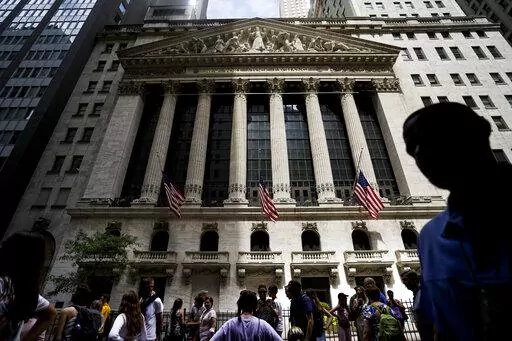 Pedestrians walk past the New York Stock Exchange on Friday, July 8, 2022, in New York. Stocks wavered between gains and losses in morning trading on Wall Street Monday, Aug. 1, 2022 as investors face another busy week of corporate earnings reports and economic updates. (AP Photo/John Minchillo, File)