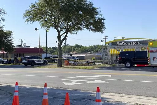 Police vehicles sit parked in front of a McDonald's restaurant as police investigate a shooting in which multiple people were killed Thursday, May 4, 2023, in Moultrie, Ga. The Georgia Bureau of Investigation said Thursday that there is more than one crime scene, including one at the McDonald’s restaurant. (Kamira Smith/The Moultrie Observer via AP)