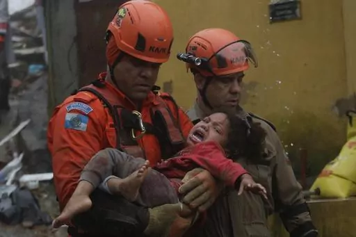 Rescue workers carry a 4-year-old girl who was rescued from her collapsed house after heavy rains in Petropolis, Rio de Janeiro state, Brazil, Saturday, March 23, 2024. (AP Photo/Bruna Prado)