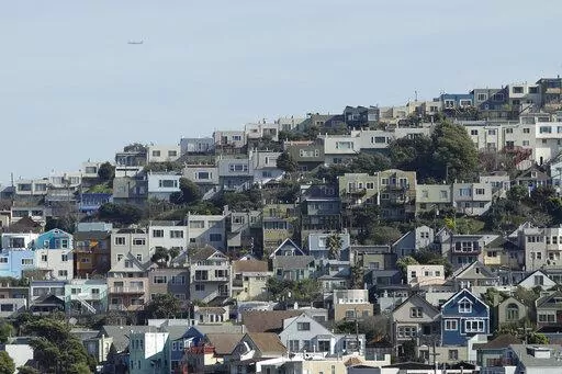 A plane flies over homes and residential buildings in San Francisco, Wednesday, March 4, 2020. California lawmakers have reached a deal on a pair of housing production bills. The bills would open up much of the state's commercial land for residential development. California has a housing shortage. (AP Photo/Jeff Chiu, File )