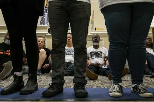 Dozens of activists stage a sit-in outside Florida Gov. Ron DeSantis' office and force people to step over them to reach DeSantis' office as they speak out against the governor and his policies, Wednesday, May 3, 2023, in Tallahassee, Fla. Florida Republicans on Wednesday approved bills to ban diversity programs in colleges and prevent students and teachers from being required to use pronouns that don't correspond to someone's sex, building on top priorities of the Republican governor. (Alicia D