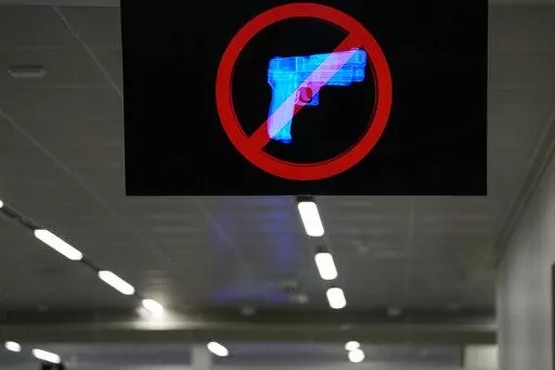 A television displays a "no guns" sign at the Transportation Security Administration security area at the Hartsfield-Jackson Atlanta International Airport on Wednesday, Jan. 25, 2023, in Atlanta. Last year saw a record number of guns intercepted at airport checkpoints across the country. The numbers have been steadily climbing and hit 6,542 last year. The head of the Transportation Safety Administration, David Pekoske, says this is a reflection of what is going on in society and in “society th