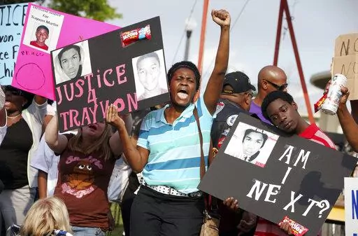 In this March 22, 2012 file photo, protestors, Lakesha Hall, of Sanford, center, and her son, Calvin Simms, right, participate in a rally for Trayvon Martin, the black teenager who was fatally shot by George Zimmerman, a neighborhood watch captain in Sanford, Fla. The killing of Trayvon Martin at the hands of a stranger still reverberates 10 years later -- in protest, in partisanship, in racial reckoning and reactionary response, in social justice and social media. (AP Photo/Julie Fletcher, File