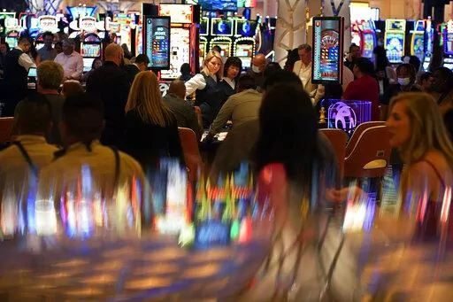 In this June 24, 2021, photo, visitors crowd the casino during the opening night of the Resorts World Las Vegas hotel-casino in Las Vegas. Nevada casinos reported near-record March 2022 house winnings, while the airport in Las Vegas reported passenger traffic almost as heavy as pre-pandemic levels and tourism officials marked another big jump in visitor volume. (AP Photo/John Locher, File)