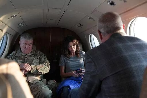 South Dakota Gov. Kristi Noem, center, checks her phone before taking off, Monday, July 26, 2021 in Pierre, S.D.  Noem is under investigation for using a state-owned airplane to fly to political events and bring family members with her on trips. But the decision on whether to prosecute the Republican governor likely hinges on how a county prosecutor interprets an untested law that was passed by voters in 2006. (AP Photo/Stephen Groves)