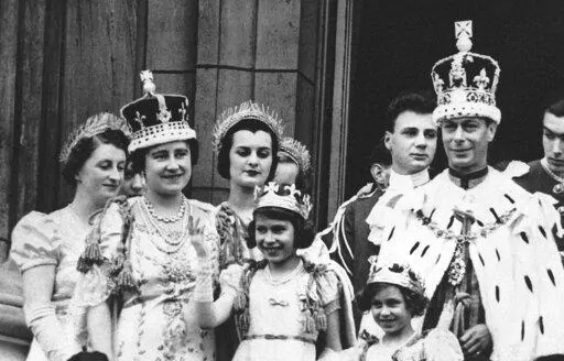 Princess Elizabeth, centre, age 11, appears on the balcony of Buckingham Palace after the coronation of her father, King George VI, right, in London, May 12, 1937. Queen Elizabeth II, Britain’s longest-reigning monarch and a rock of stability across much of a turbulent century, has died. She was 96. Buckingham Palace made the announcement in a statement on Thursday Sept. 8, 2022. (AP Photo, File)