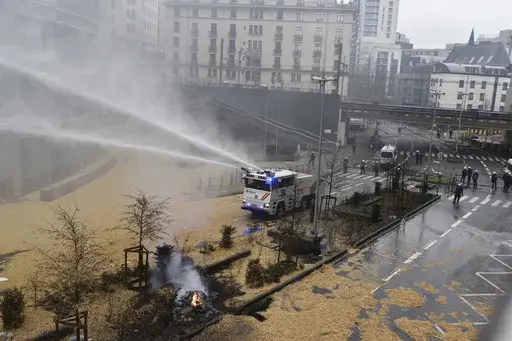 Police spray a water canon during a farmers demonstration in the European Quarter outside a meeting of EU agriculture ministers in Brussels, Monday, Feb. 26, 2024. European Union agriculture ministers meet in Brussels Monday to discuss rapid and structural responses to the crisis situation facing the agricultural sector. (AP Photo/Harry Nakos)