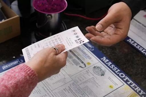 A customer purchases five Powerball tickets at a lottery agent, Tuesday, Oct. 10, 2023, in Haverhill, Mass. (AP Photo/Charles Krupa, File)