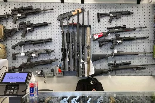 Firearms are displayed at a gun shop in Salem, Ore., on Feb. 19, 2021. A federal judge in Portland, Ore., ruled Tuesday, Dec. 6, 2022, that a new voter-passed ban on high-capacity gun magazines can go into effect Thursday, Dec. 8, but placed a 30-day hold on a permit-to-purchase requirement after local and state law enforcement agencies said they could not have a permitting system ready in time. (AP Photo/Andrew Selsky, File)