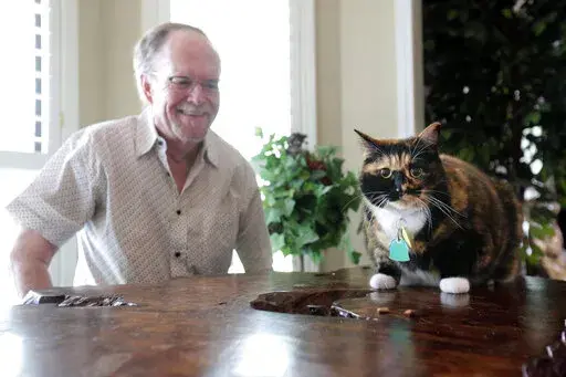 Fred Everitt of Tupelo, Miss., is all smiles after his cat, "Bandit", alerted him in the middle of the night that two men were trying to break into the back door of his home, July 29, 2022, in Tupelo, Miss. (Thomas Wells/Northeast Mississippi Daily Journal via AP)