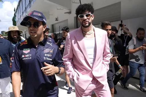 Red Bull driver Sergio Perez, of Mexico, left, walks with Puerto Rican reggaeton musician Bad Bunny before a Formula One Miami Grand Prix auto race at Miami International Autodrome in Miami Gardens, Fla., on May 8, 2022. As the sport grows in popularity, race weekends are transforming into mini music festivals with A-list talent performing after the day's event. (AP Photo/Lynne Sladky, File)