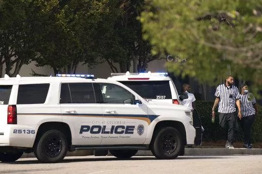 Foot Locker store employees walk near police vehicles outside Columbiana Centre mall in Columbia, S.C., following a shooting, Saturday, April 16, 2022. (AP Photo/Sean Rayford)