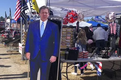 A cardboard cutout of Florida Gov. Ron DeSantis stands in the merchandise area outside former President Donald Trump's rally in Conroe, Texas, Saturday, Jan. 29, 2022. At Trump’s rally, there were signs of change. Next to the Trump hats, shirts and flags sat a collection of Ron “DeSantis 2024” bumper stickers. The vast majority of those interviewed at Trump’s rally enthusiastically cheered the prospect of another Trump run. But there were some who conceded that, perhaps, there might be a