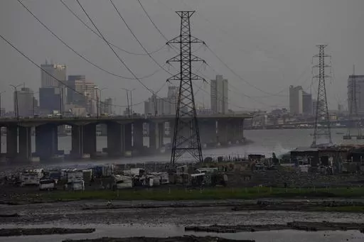 High tension power lines pass through Makoko slum in Lagos, Nigeria, Saturday, Aug. 20, 2022. From Zimbabwe, where many must work at night because i t's the only time there is power, to Nigeria where collapses of the grid are frequent, the reliable supply of electricity remains elusive across Africa. (AP Photo/Sunday Alamba/File)