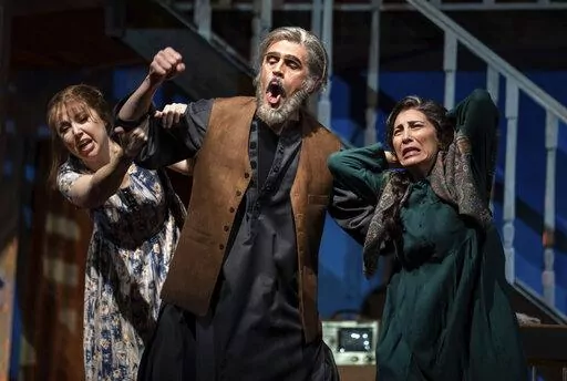 Maureen McKay, left, who portrays Laila, John Moore, who portrays Rasheed, and Karin Mushegain, who portrays Mariam, perform in a dress rehearsal for the opera "A Thousand Splendid Suns," in Seattle, on Wednesday, Feb. 22, 2023. Making its world debut Saturday, Feb. 25, 2023, it is based on a popular novel by Kabul-born author Khaled Hosseini that explores the inner worlds of Mariam and Laila over decades of Afghan history, some with stark parallels to the present. (AP Photo/Stephen Brashear)