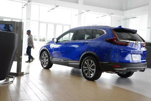 A potential buyer surveys a 2022 CR-V sports-utility vehicle on the showroom floor of a Honda dealership, Thursday, Nov. 3, 2022, in Highlands Ranch, Colo. (AP Photo/David Zalubowski, File)