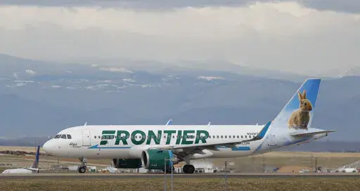 A Frontier Airlines jetliner taxis to a runway to take off from Denver International Airport Thursday, April 23, 2020, in Denver. Frontier Airlines' parent company is buying Spirit Airlines in a $2.9 billion cash-and-stock deal that will allow the combined airline to be more competitive against its larger rivals. (AP Photo/David Zalubowski, File)