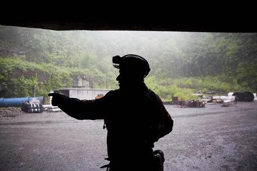 Coal miner Scott Tiller takes shelter from the rain after coming out of an underground mine at the end of a shift in Welch, W.Va., May 12, 2016. The sprawling economic package passed by the U.S. Senate this week has a certain West Virginia flavor. The bill could be read largely as an effort to help West Virginia look to the future without turning away entirely from its roots. (AP Photo/David Goldman, File)