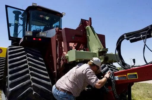 Farmer Nathan Weathers configures a high-power, high-tech quad-track tractor near his farm in Yuma, Colo, June 30, 2008. Lawmakers in Colorado and 10 other states have introduced bills that would force farming equipment manufacturers to provide the tools, software, parts and manuals needed for farmers to do their own repairs. The bills are a response to farmers unable to repair their own tractors and combines, forcing them to wait sometimes days and paying steep labor costs. (Brian Brainerd/The 