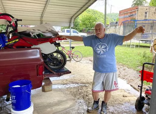 Paul Francis describes how flood waters damaged his property in Garrett, Ky., Saturday, July 30, 2022. Francis was born in the home 73 years ago but his wife wants to leave the area because of the flooding. The tiny town of Garrett was completely under water when floodwaters struck eastern Kentucky last week. (AP Photo/Dylan Lovan)