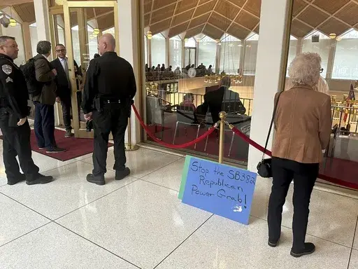 A placard expressing opposition to a Republican-penned measure being debated sits outside the North Carolina Senate gallery at a Legislative Building news conference in Raleigh, N.C., Wednesday, Nov. 20. 2024. (AP Photo/Gary D. Robertson)