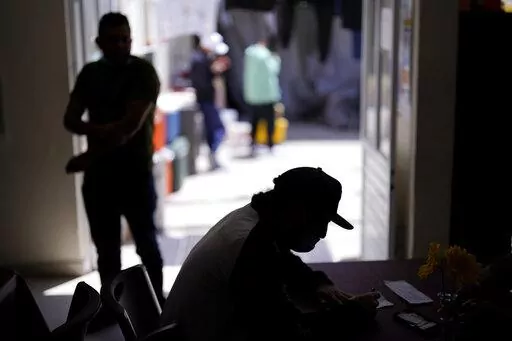 A man from Nicaragua sits at a shelter for migrants Thursday, April 21, 2022, in Tijuana, Mexico. The man is waiting in Mexico for hearings in U.S. immigration court, part of a Trump-era policy that will be argued Tuesday before the U.S. Supreme Court. (AP Photo/Gregory Bull)