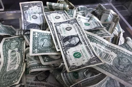 In this April 3, 2019, photo a tip box is filled with U.S. currency in New York. During inflation, consumers can adjust their spending and saving strategies to help lessen the impact that inflation has on the value of their money. It’s important to have liquid cash set aside for emergencies, but beyond an emergency fund, there are other ways to save money and help retain its value. (AP Photo/Mark Lennihan, File)