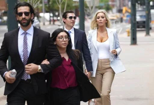 The son, left, and daughter, back right, of Pittsburgh dentist Lawrence "Larry" Rudolph head into federal court for the afternoon session of the trial, July 13, 2022, in Denver. Rudolph accused of shooting and killing his wife in their cabin at the end of an African safari trip has denied that he killed her. Rudolph took the stand Wednesday, July 27, 2022, at his murder trial in Denver federal court. (AP Photo/David Zalubowski, File)