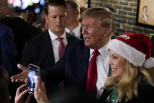 Former President Donald Trump greets supporters during a stop at the Front Street Pub & Eatery, Tuesday, Dec. 5, 2023, in Davenport, Iowa. (AP Photo/Charlie Neibergall)