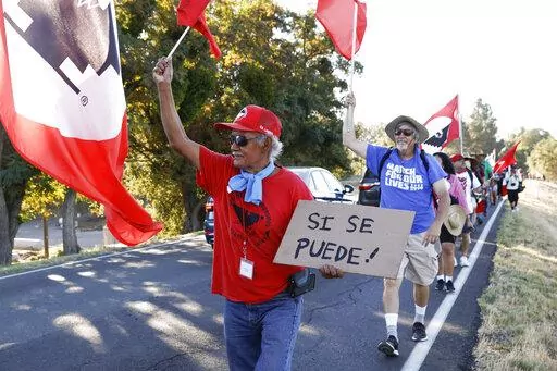 Asunción Ponce, left, marches with fellow members of the United Farm Workers in support of a bill that would allow farmworkers to vote by mail in union elections, near Walnut Grove, Calif., Wednesday, Aug. 24, 2022. Gov. Gavin Newsom, on Wednesday, Sept. 28, 2022, signed the measure. (Jessica Christian/San Francisco Chronicle via AP, File)