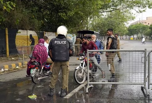 Pakistani security officials close a road outside the former Prime Minister Imran Khan's residence in Lahore, Pakistan, Thursday, May 18, 2023. Pakistani police kept up their siege around the home of Khan as a 24-hour deadline given to the former premier to hand over suspects allegedly sheltered inside was about to expire on Thursday. (AP Photo/K.M. Chaudary)