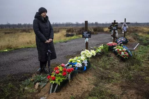 Svetlana Shornik stands next to the grave of her 53-year-old ex-husband, Oleh Shornik, on the outskirts Kherson, Ukraine, on Sunday, Nov. 20, 2022. Oleh Shornik was among 20 civilian volunteers of Ukraine’s Territorial Defense Forces killed by Russian troops in March in the southern city before it fell to Moscow. Russia held it for eight months before retreating in November. (AP Photo/Bernat Armangue)