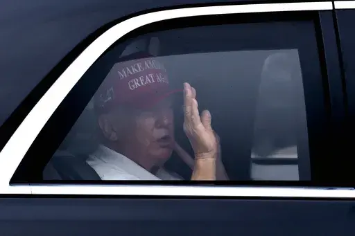 President Donald Trump waves from his vehicle as he arrives at the Trump International Golf Club, Monday, Feb. 17, 2025, in West Palm Beach, Fla. (AP Photo/Ben Curtis)