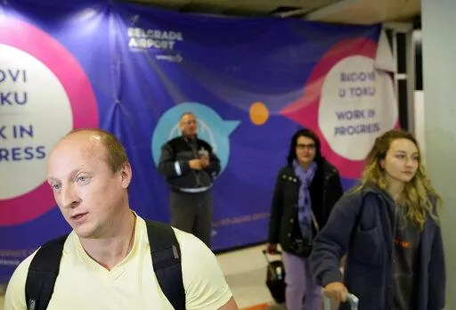 Vladimir, a passenger from the Moscow-Belgrade flight operated by Air Serbia, speaks to the media at the airport in Belgrade, Serbia, Wednesday, Sept. 21, 2022. Large numbers of Russians rushed to book one-way tickets out of the country while they still could after Russian President Vladimir Putin announced a partial mobilization of military reservists for the war in Ukraine. (AP Photo/Darko Vojinovic)