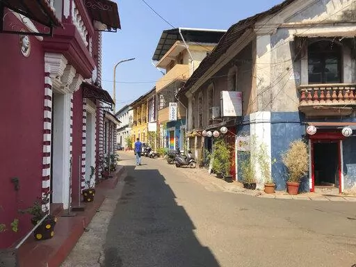 A man walks through a deserted street at Fontainhas, a UNESCO heritage site with Portugese style homes in Panjim, Goa, on Feb. 12, 2022. India's undisputed tourist hot spot, and the tiniest state in the world's largest democracy, is voting Monday to elect a new government with an eye toward restoring an economy ravaged by the pandemic and saving the environment threatened by an unbridled real estate boom. (AP Photo/Vineeta Deepak)