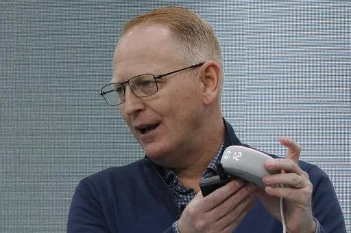 Dave Limp, senior vice president for Amazon devices & services, holds an Echo Dot with Clock device as he speaks Sept. 25, 2019, in Seattle. Amazon and telemedicine provider Teladoc Health are starting a voice-activated virtual care program that lets customers get medical help without picking up their phones. The service, for health issues that aren’t emergencies, will be available on Amazon’s Echo devices. Customers can tell the voice assistant Alexa that they want to talk to a doctor, and 