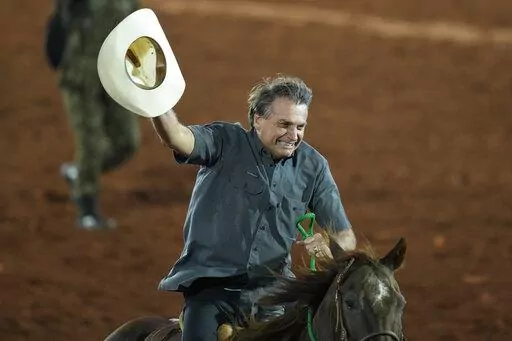 Brazilian President Jair Bolsonaro, who is running for a second term, rides a horse at the the Barretos Rodeo International Festival in Barretos, Sao Paulo state Brazil, Friday, Aug. 26, 2022. Brazil's general elections are scheduled for Oct. 2, 2022. (AP Photo/Andre Penner)