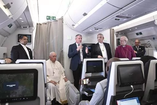 The Archbishop of Canterbury Justin Welby, right, Pope Francis,left, and the Moderator of the General Assembly of the Church of Scotland Iain Greenshields meet the journalists during an airborne press conference aboard the airplane directed to Rome, at the end of his pastoral visit to Congo and South Sudan, Sunday, Feb. 5, 2023. (Tiziana Fabi/Pool Photo Via AP)