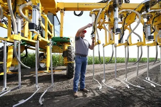 Jake Klocke, of PowerPollen, prepares a pollen applicator, Thursday, Aug. 22, 2024, near Ames, Iowa. (AP Photo/Charlie Neibergall)