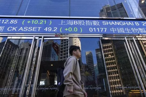 A pedestrian passes by the Hong Kong Stock Exchange electronic screen in Hong Kong, on Wednesday, March 1, 2023. Asian shares were mixed Wednesday as investors watched for upcoming earnings reports and other indicators on how inflationary pressures might be denting global growth. (AP Photo/Louise Delmotte)
