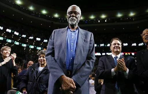 Boston Celtics legend Bill Russell stands court side during a tribute in his honor in the second quarter of an NBA basketball game against the Milwaukee Bucks in Boston, Nov. 1, 2013. The NBA great Bill Russell has died at age 88. His family said on social media that Russell died on Sunday, July 31, 2022. Russell anchored a Boston Celtics dynasty that won 11 titles in 13 years. (AP Photo/Michael Dwyer, file)