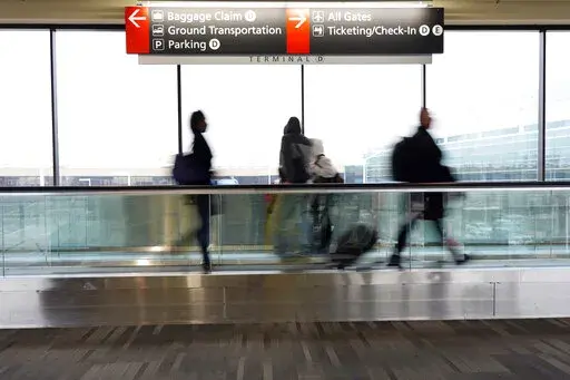FILE - Travelers walk to their gates at the Philadelphia International Airport on Friday, Dec. 31, 2021, in Philadelphia. Wintry weather combined with the pandemic to frustrate air travelers whose return flights home from the holidays were canceled or delayed in the first days of the new year. (AP Photo/Michael Perez)