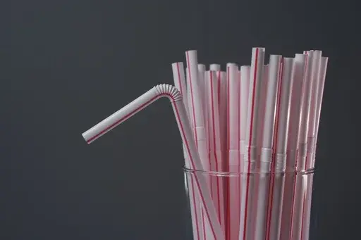Plastic straws are displayed in a glass, Tuesday, Feb. 11, 2025, in Cincinnati. (AP Photo/Joshua A. Bickel)