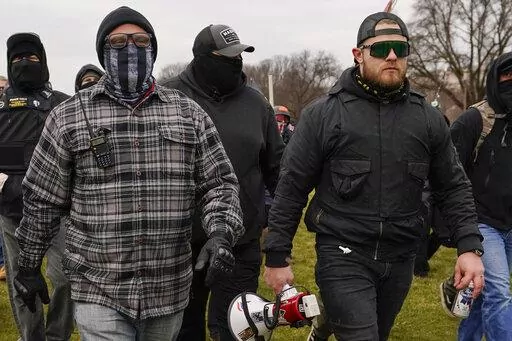 FILE - Proud Boys members Joseph Biggs, left, and Ethan Nordean, right with megaphone, walk toward the U.S. Capitol in Washington, Jan. 6, 2021. A federal judge on Tuesday, Dec. 28 refused to dismiss an indictment charging four alleged leaders of the far-right Proud Boys, Ethan Nordean, Joseph Biggs, Zachary Rehl and Charles Donohoe, with conspiring to attack the U.S. Capitol to stop Congress from certifying President Joe Biden's electoral victory. (AP Photo/Carolyn Kaster, File)