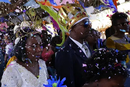 Adonildes da Cunha, right, Emperor, and Nilda dos Santos, left, Queen, arrive for a celebration after a Mass in the chapel of the Kalunga quilombo, during the culmination of the week-long pilgrimage and celebration for the patron saint "Nossa Senhora da Abadia" or Our Lady of Abadia, in the rural area of Cavalcante in Goias state, Brazil, Monday, Aug. 15, 2022. Devotees, who are the descendants of runaway slaves, celebrate Our Lady of Abadia at this time of the year with weddings, baptisms and b